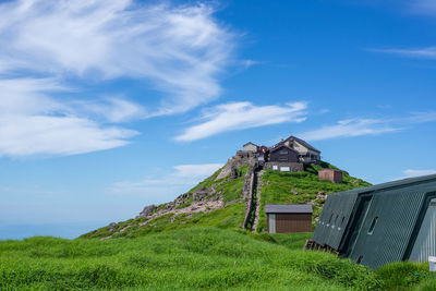 Panoramic shot of cottage on field against sky