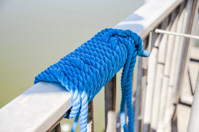 Close-up of blue rope tied on railing