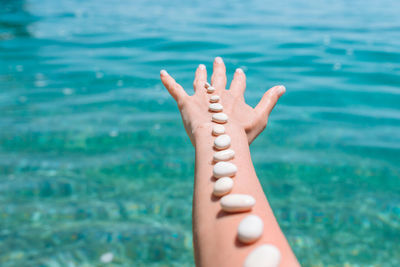 Close-up of hand against sea