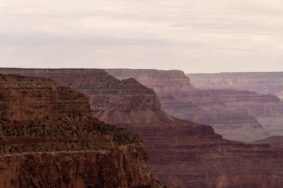 Rock formations on landscape against cloudy sky