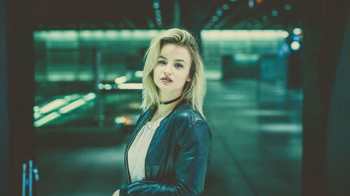 Portrait of young woman standing at railroad station