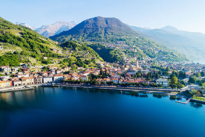 Scenic view of town by mountains against clear sky