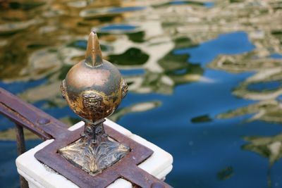 Close-up of metallic railing by pond