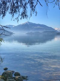 Scenic view of sea by mountains against sky