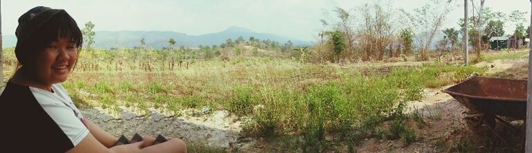 lifestyles, leisure activity, mountain, landscape, sky, tranquility, standing, grass, tranquil scene, scenics, nature, young adult, field, person, beauty in nature, rear view, plant, casual clothing