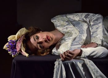 Thoughtful woman wearing flowers on hair while lying down on table