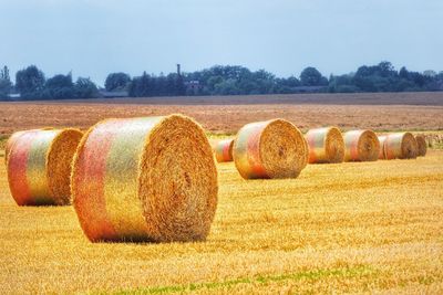 Hay bales on field against sky