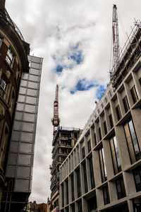 Low angle view of buildings against cloudy sky