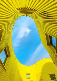 Low angle view of yellow building against sky