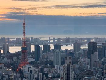 Modern buildings in city against sky during sunset