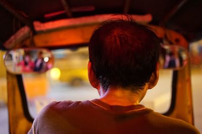 Rear view of man sitting in jinrikisha