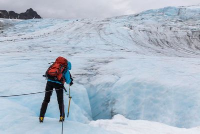 Person on snow covered mountain against sky