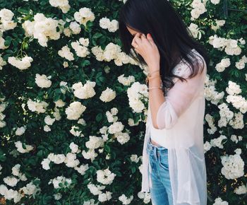 Midsection of woman standing by flowers