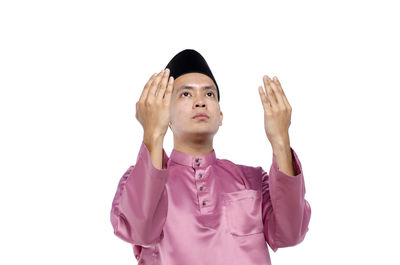 Portrait of young man looking away against white background