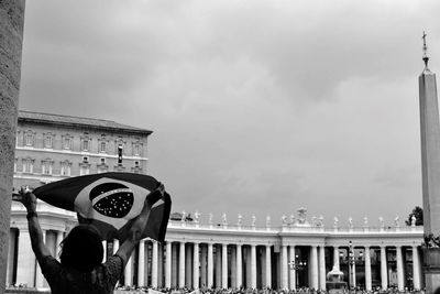 People standing against cloudy sky