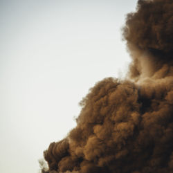 Low angle view of smoke explosion against clear sky