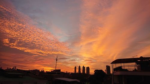 Silhouette buildings against sky during sunset