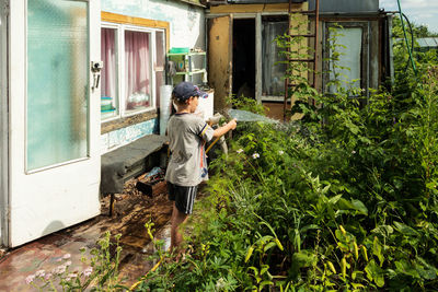 People standing by plants against building