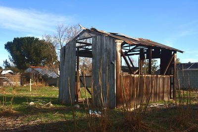 Abandoned house on field against sky