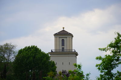 Low angle view of trees and building against sky