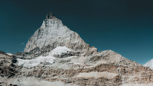 Panoramic view of snowcapped mountains against clear blue sky
