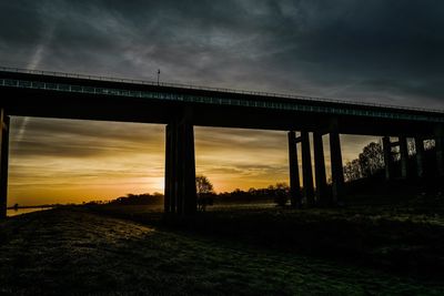 Bridge against dramatic sky during sunset