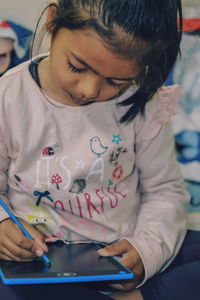 Close-up of girl writing in her slate