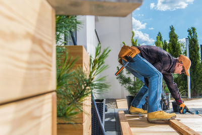 Man working on wood against trees