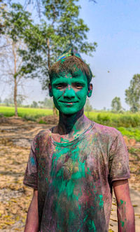 Portrait of boy  standing against trees