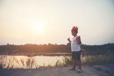 Boy with cape and eye patch playing in park