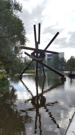 Traditional windmill by trees against sky