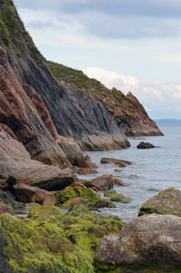 Rock formations by sea against sky