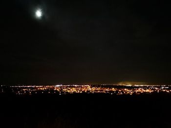 Illuminated city against sky at night