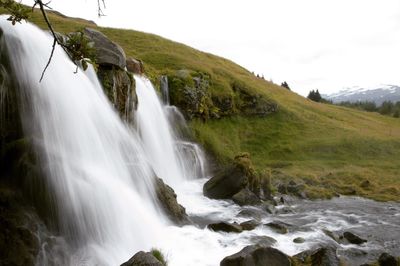 Scenic view of waterfall against sky