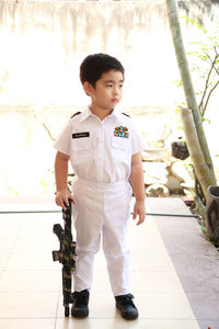 Cute boy looking away while standing outdoors