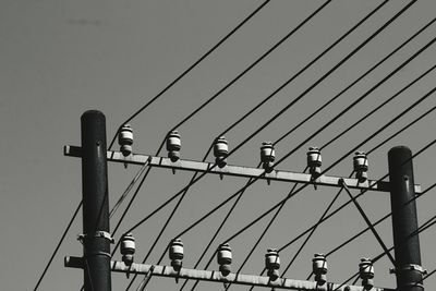 High section of electricity cables against clear sky