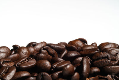 Close-up of coffee beans against white background