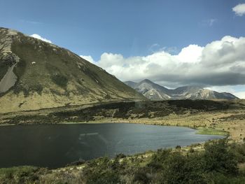 Scenic view of lake by mountains against sky