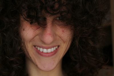 Close-up portrait of young woman with curly hair