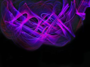 Close-up of multi colored light painting against black background