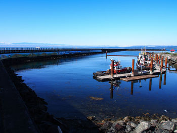 Boats in sea against clear sky