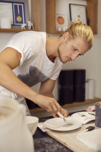 Young craftsperson working in crockery workshop