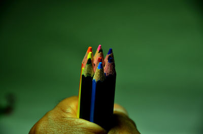 Close-up of hand holding colored pencils