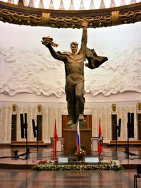 Low angle view of woman standing against statue