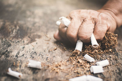 Cropped image of hand crushing cigarettes