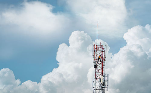 Telecommunication tower with blue sky and white clouds. worker installed 5g equipment.