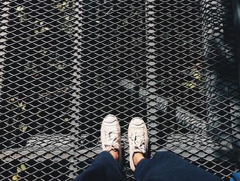 Low section of man standing on fence