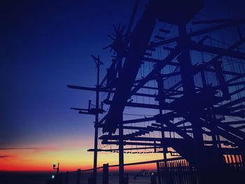 Low angle view of silhouette bridge against sky at sunset