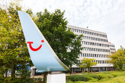 Low angle view of sign by building against sky