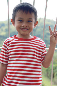 Portrait of boy gesturing while standing outdoors